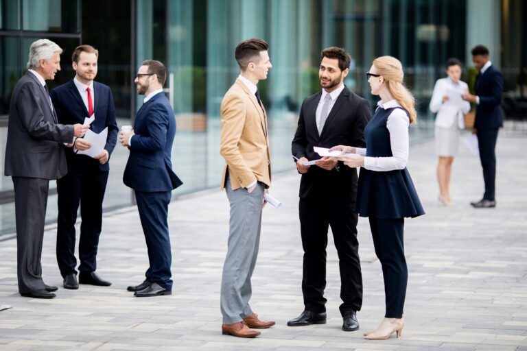 Well dressed executives conversing in groups outside of office building